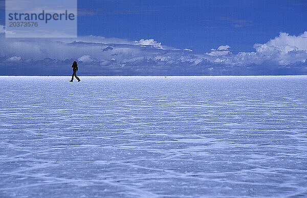 Eine Frau durchquert den Salar de Uyuni  die größte Salzwüste der Welt im Südwesten Boliviens.