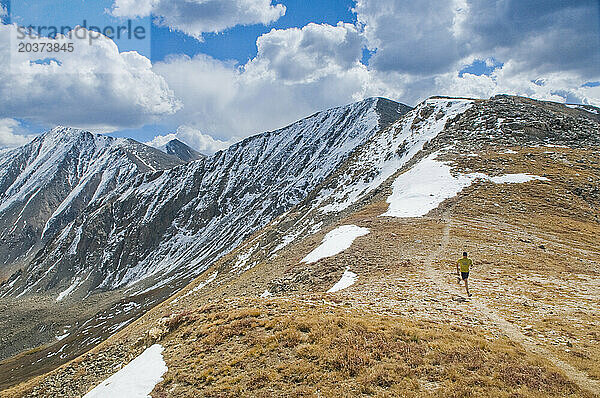 Ein Mann läuft entlang eines Alpenrückens mit dem Torreys Peak im Hintergrund  CO.