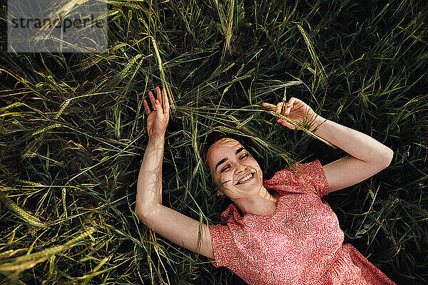 Porträt eines glücklichen Mädchens  das im Gras liegt