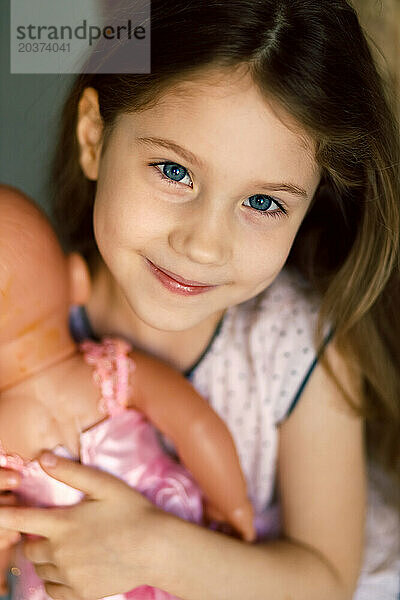 Porträt eines glücklichen Kindes mit Puppe