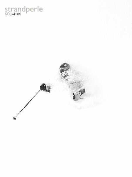 Das Gesicht einer Skifahrerin ist vollständig mit Pulverschnee bedeckt  als sie einen Berg in Niseko  Japan  hinunterfährt.