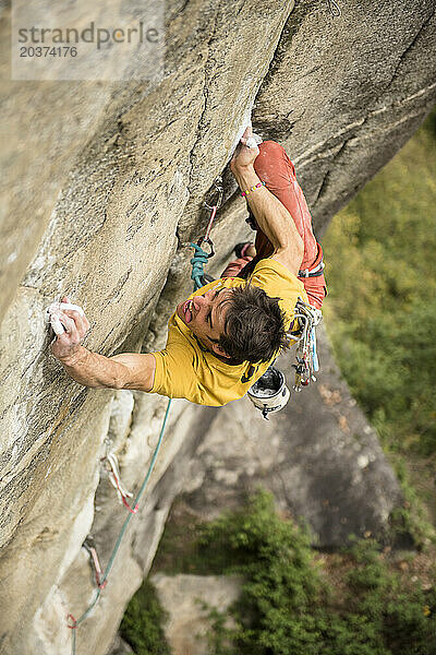 Mann klettert eine 8c (5 14b) Sportroute in Ossola  Italien.