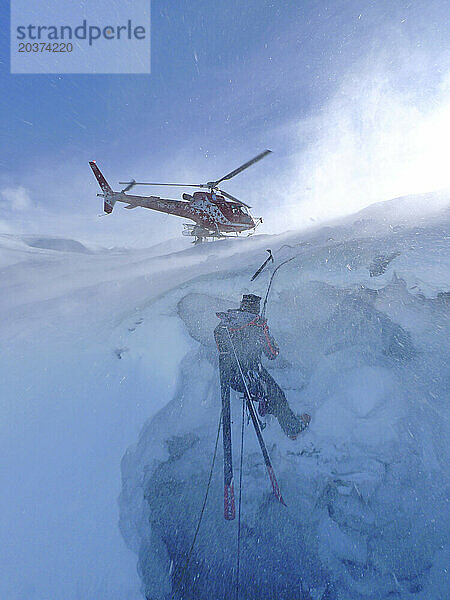 Ein Bergrettungstechniker stürzt in eine Gletscherspalte. Wenn ein Skifahrer abseits der Piste den Schnee durchbricht und den Gletscher hinunterstürzt  besteht der einzige Ausweg darin  ihn mit einer Winde hochzuziehen