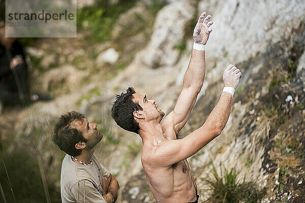 Ein Kletterer zeigt seinem Freund die Bewegungen einer Kletterroute. Mallorca  Spanien.