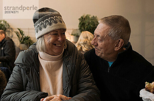 Ein Rentnerpaar in den Siebzigern saß lachend zusammen in einem Café