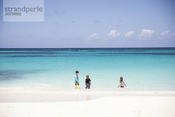Drei Geschwister spielen im blauen Karibischen Meer in Shoal Bay  Anguilla