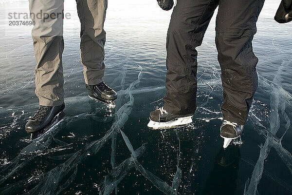 Zwei Personen Eislaufen auf dem zugefrorenen Baikalsee  Sibirien  Russland.