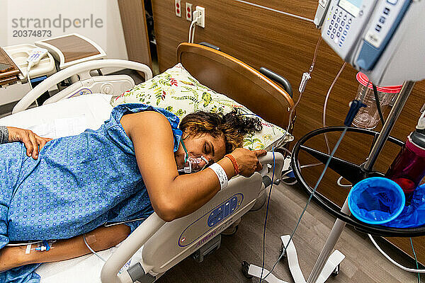 Indische Mutter atmet während Wehen im Krankenhaus Sauerstoff ein