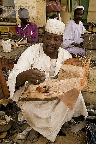 Lederreparaturwerkstatt auf einem Markt in El Obeid  Nordkordofan  Sudan. Er repariert einen Kamelsattel.