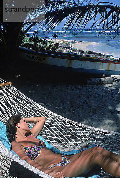 Eine junge Frau im Bikini entspannt sich in der Hängematte am Strand  Virgin Island  USA.