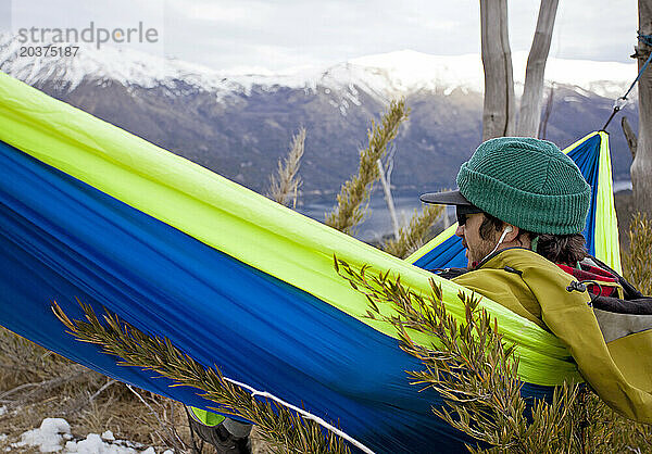 Ein Mann entspannt sich in einer Hängematte  während er den Wald in der Nähe des Cerro Catedral erkundet