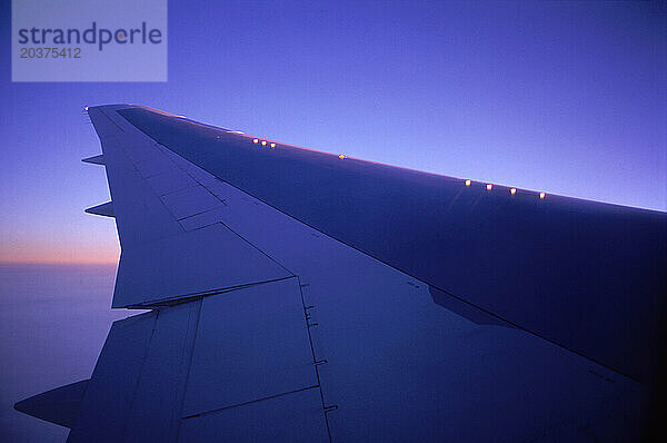 Flugzeugflügel über dem Himmel bei Sonnenuntergang