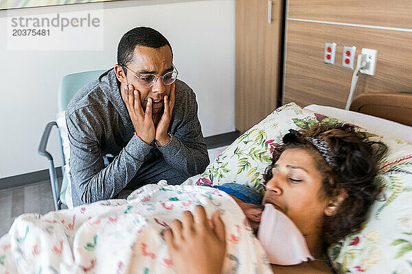 Afroamerikanischer Vater ist von Gefühlen überwältigt  als er sein Neugeborenes ansieht