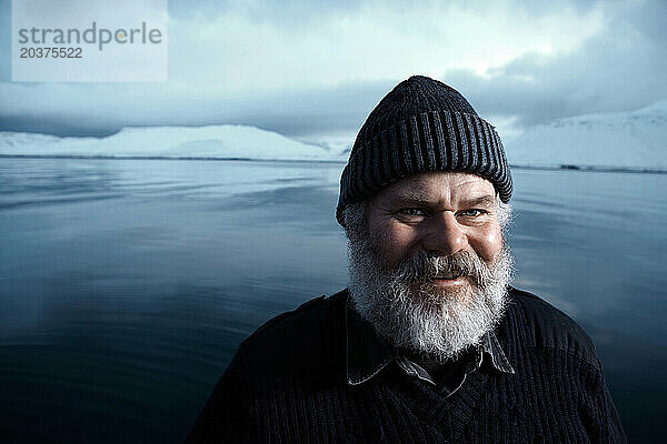 Ein Mann mit grauem Bart in der Winterlandschaft