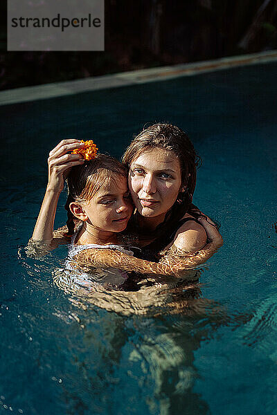 Junge Mutter mit ihrer Tochter im Pool.