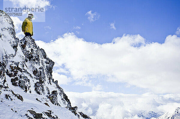 Ein Mann blickt an einem sonnigen Tag am Cerro Catedral in Argentinien auf eine Klippe