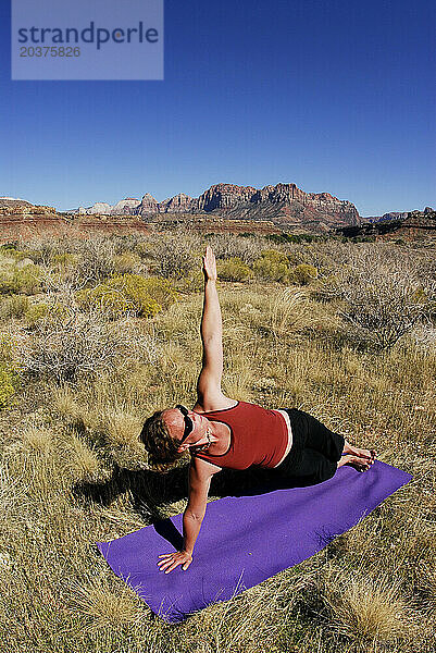 Eine Frau macht Yoga draußen in Springdale  Utah.