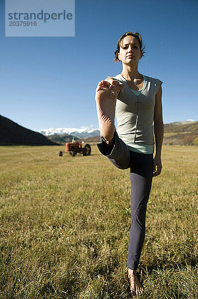 Eine Frau praktiziert Yoga an einem Herbstnachmittag in den Rocky Mountains