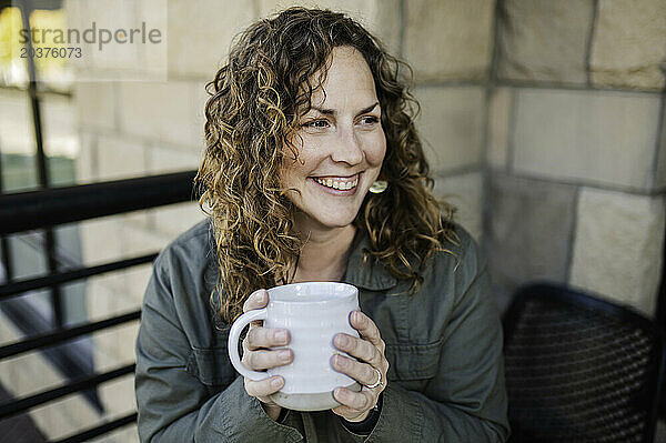 Frau lächelt mit Kaffeetasse