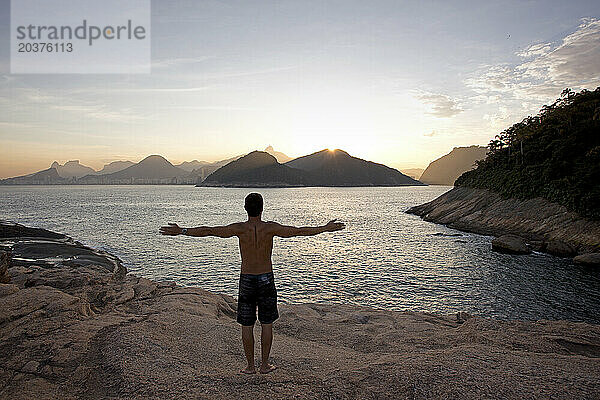 Ein Mann mit offenen Armen blickt auf Rio de Janeiro  Brasilien.