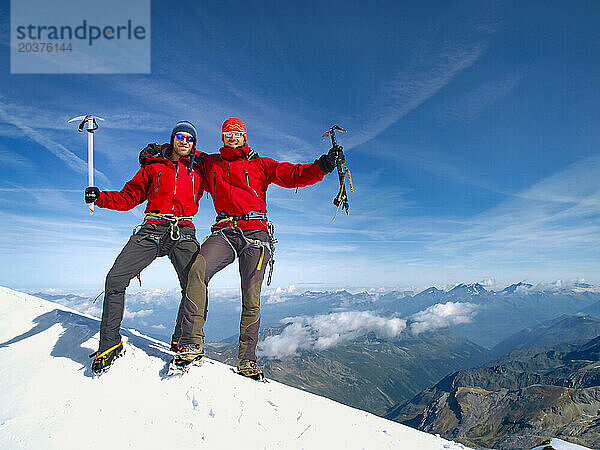 Zwei Alpinkletterer freuen sich auf dem Gipfel des Bishorns  einem Berg in den Schweizer Alpen.