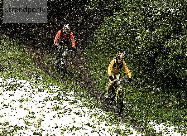 Ein Mann und eine Frau beim Mountainbiken in den französischen Alpen im Frühling in Bourg St. Maurice  Savoie  Frankreich.