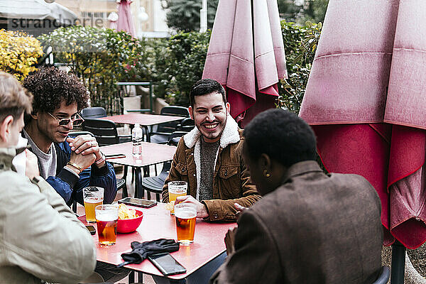 Vier multiethnische Freunde trinken Bier und reden