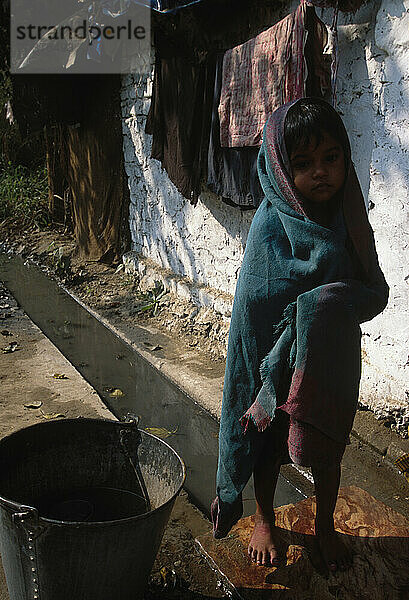 Ein junges Mädchen in einem Slum in Delhi  Indien. Die Bewohner wohnen unterhalb der Leitung  die die Stadt mit Wasser versorgt. Diese Leute haben Handpumpen  mit denen sie Grundwasser zum Baden gewinnen