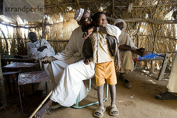 Kamelhändler Elsean Ahmed Naiem mit seinem Sohn Ali Mohammed Abo in einer Teehütte auf dem Kamelmarkt in El Obeid  Nordkordofan  Suda