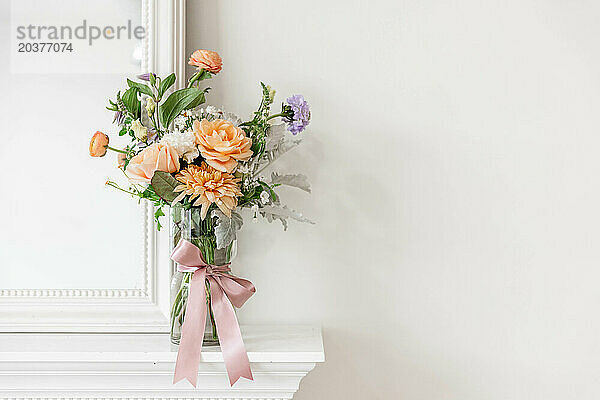 Buntes pastellfarbenes Blumenstrauß-Arrangement in einer klaren Vase
