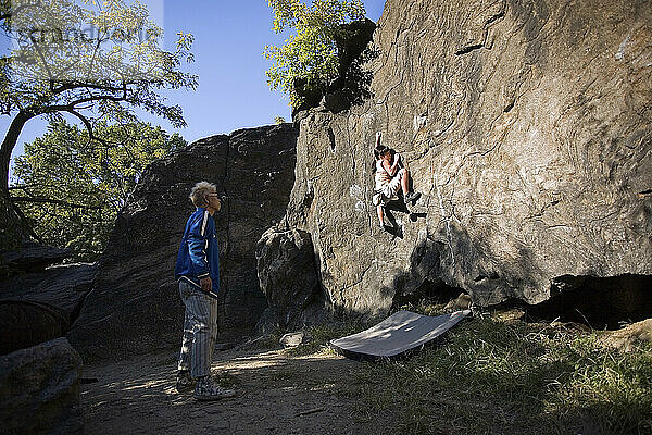 Eine junge Kletterin beim Bouldern mit ihrem Vater im Central Park.