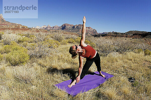 Eine Frau macht Yoga draußen in Springdale  Utah.