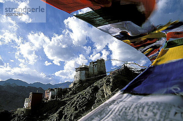 Auf einem Felsvorsprung über der Stadt Leh liegt Namgyal Gompa  geschützt durch im Wind flatternde Gebetsfahnen  Ladakh  Indien.