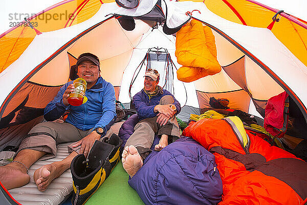 Zwei Bergsteiger unterhalten sich gut  während sie sich in einem Zelt am Kahiltna-Gletscher ausruhen