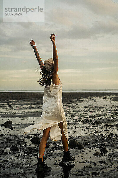 Glückliche junge Frau am Strand bei Sonnenuntergang  Medewi