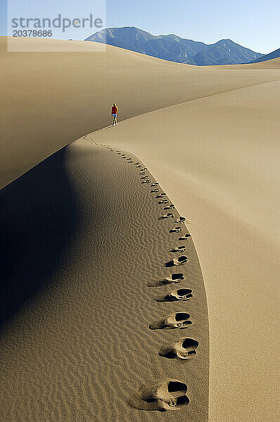 Eine Frau geht über den Kamm einer Düne im Great Sand Dunes National Park  Colorado.