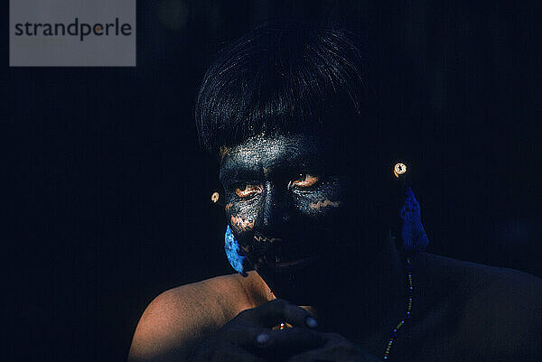 Yanomami-Indianer mit schwarz bemaltem Lieblingsfavoriten und Federohrschmuck  bereit für ein Fest. Im Amazonaswald im Süden Venezuelas.