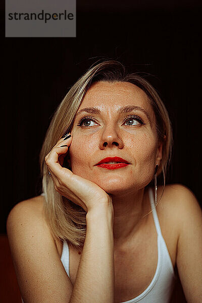 Emotionales Porträt einer blonden Europäerin mittleren Alters.