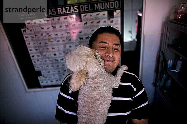 Ein Mann umarmt seinen französischen Pudelhund in einer Tierklinik in Condesa  Mexiko-Stadt  Mexiko