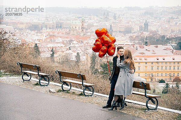 Junges Paar geht mit Luftballons im Herzen durch Prag