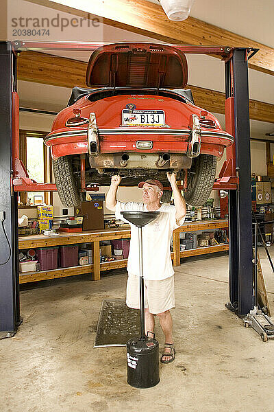 Ein Mann arbeitet in seiner Garage in Pennsylvania an seinem antiken Sportwagen.