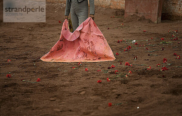 Ein Stierkämpfer steht zwischen von Fans geworfenen Rosen und wartet während eines Stierkampfs in Mexiko-Stadt darauf  dass ein Stier angreift.