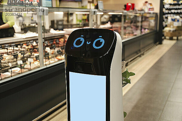 Cute delivery robot roaming at supermarket