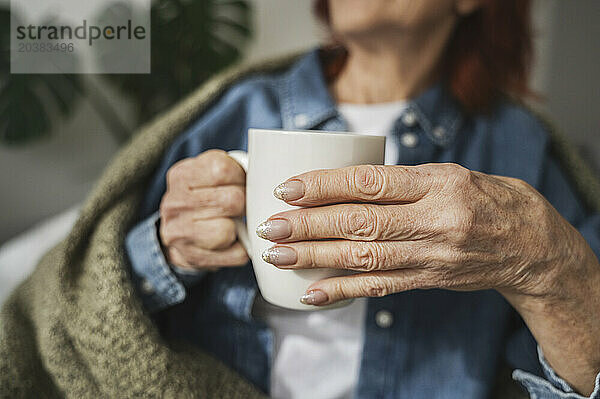 Hands of senior woman holding tea mug