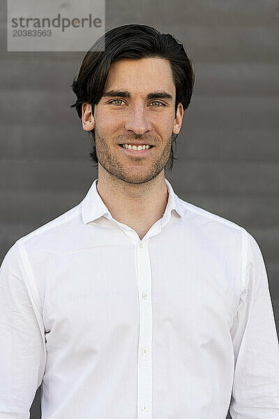 Smiling young businessman in white shirt