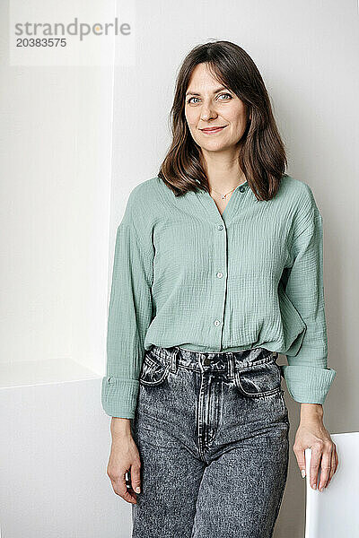 Smiling woman standing in front of wall