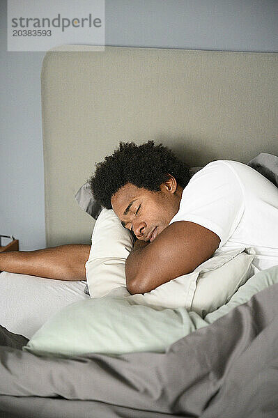 Man lying on bed sleeping in bedroom