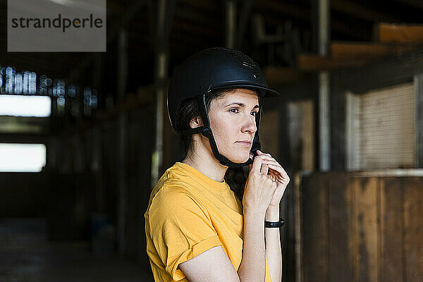 Instructor wearing helmet at stable