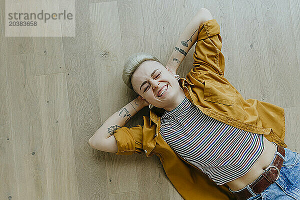 Carefree woman lying down on hardwood floor