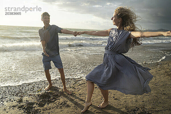 Couple enjoying dance at windy beach